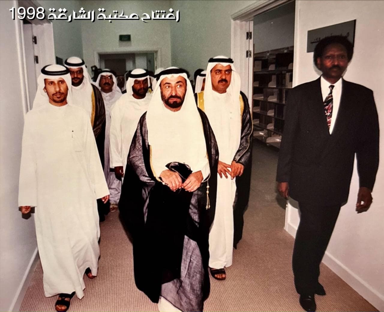 Modern library interior with curved white shelves, yellow bookcases, and seating
